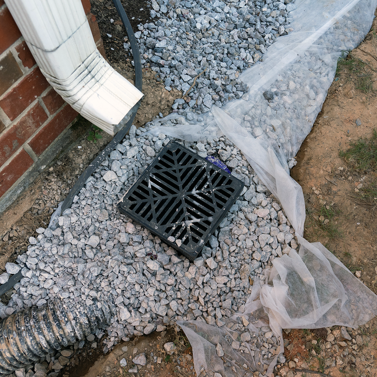 Plastic catch basin installed under a downspout